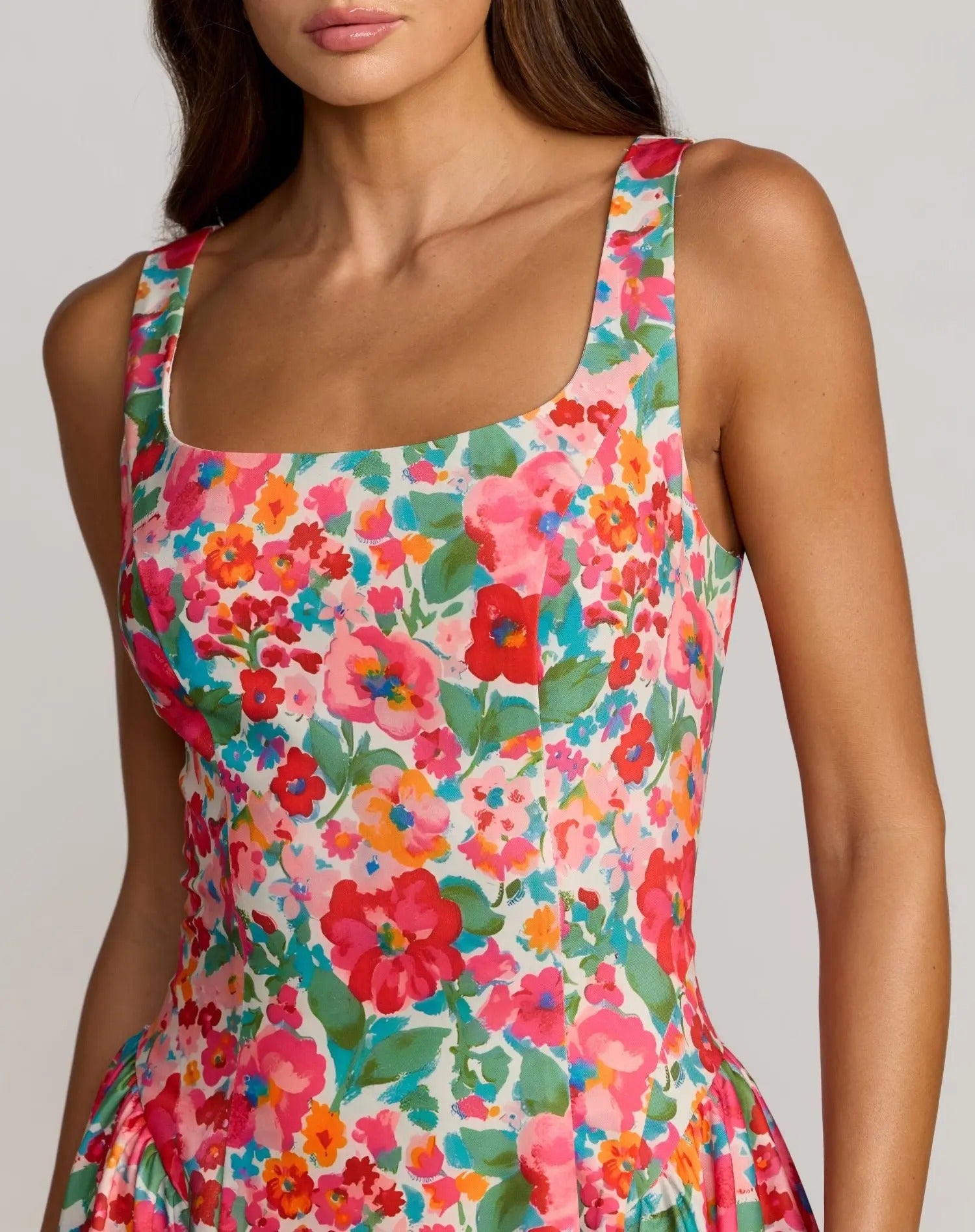 A woman wearing the Floral Midi Wedding Guest Dress: Mac Duggal 37155, a sleeveless crepe midi dress featuring a square neckline and a bright, colorful floral pattern—perfect for weddings.